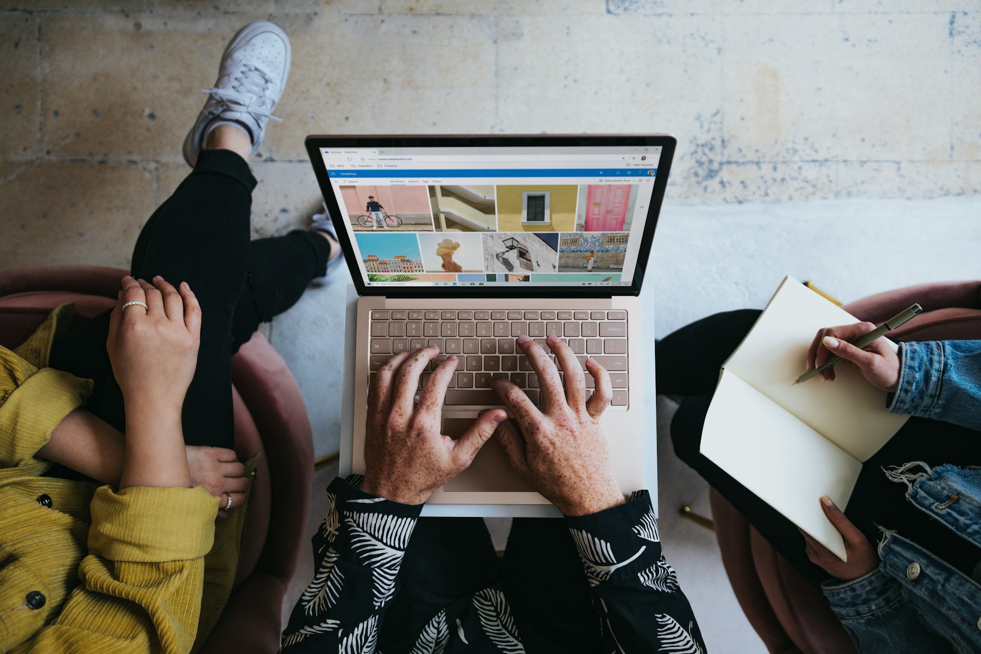 Curso introducción al Marketing Digital sijap person using microsoft surface laptop on lap with two other people